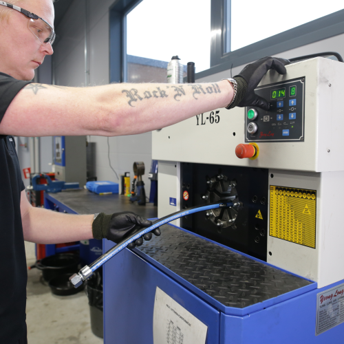 Tekninen myyjä valmistaa hydrauliletkua.